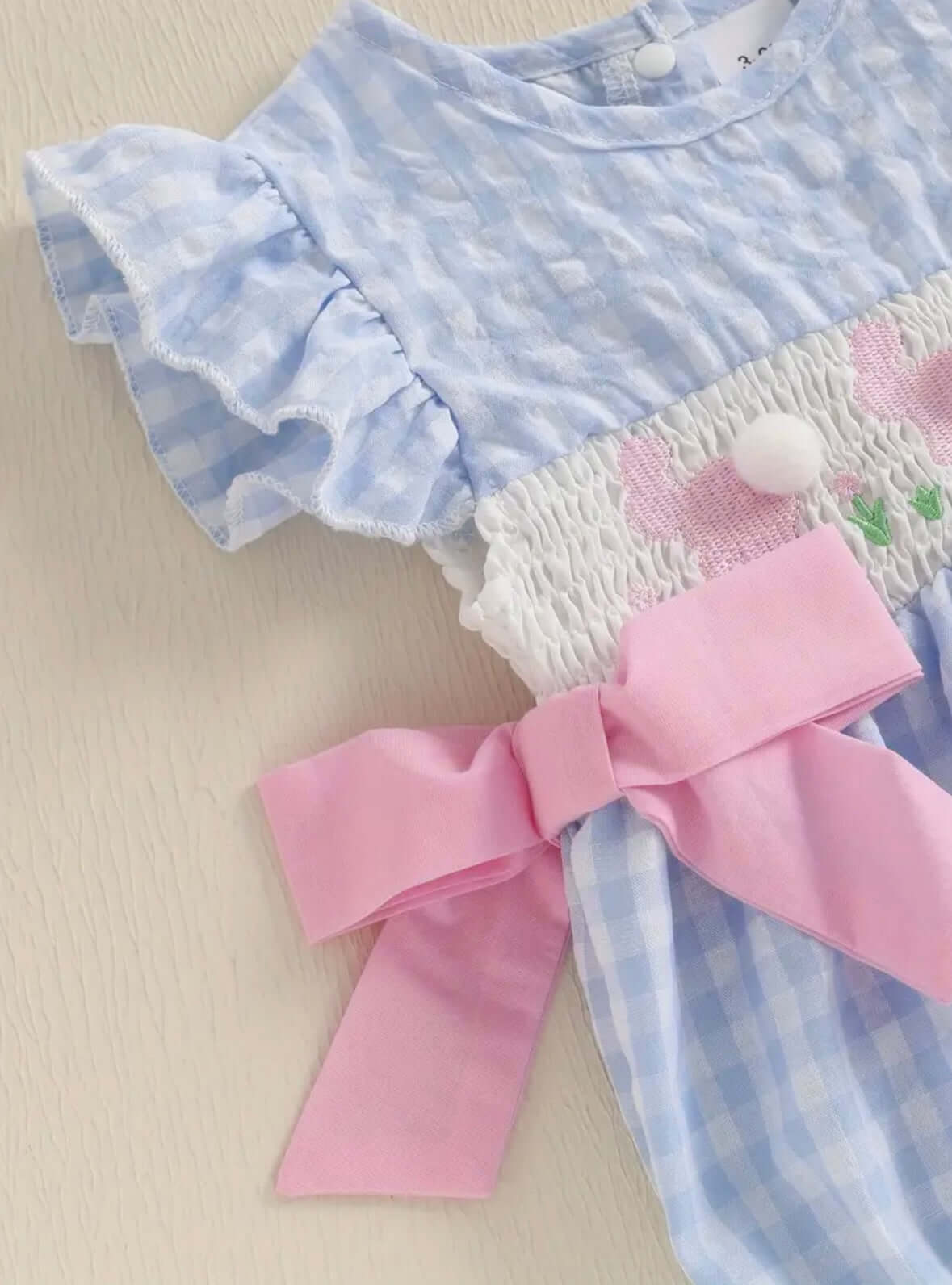 Light blue ruffled sleeve dress with pink bow and soft cotton blend, featuring cute rabbit embroidery for baby girls.